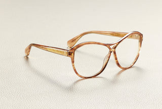 Emmanuelle acetate glasses in vintage tortoise, resting on cream leather