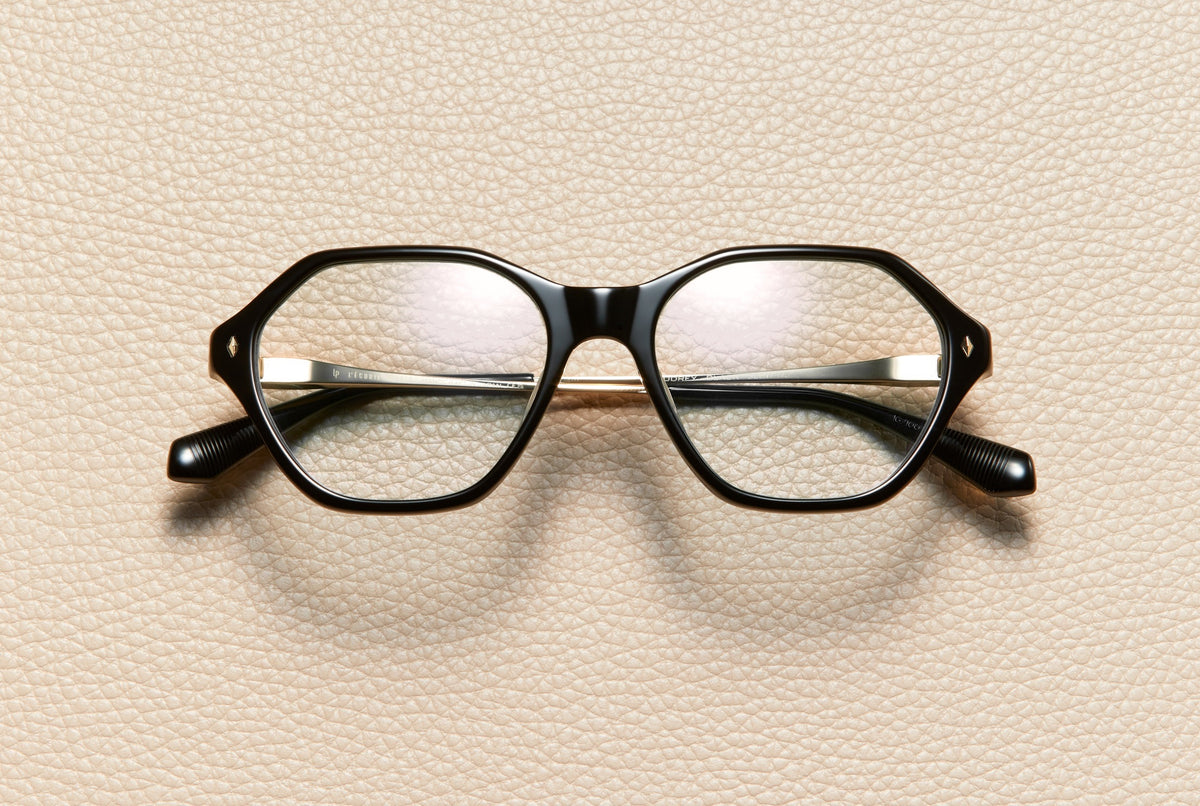 Audrey Black optical frame by L'Écurie Paris, hexagonal polished black acetate with 18K gold-plated titanium temples, prescription ready