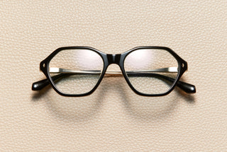 Audrey Black optical frame by L'Écurie Paris, hexagonal polished black acetate with 18K gold-plated titanium temples, prescription ready