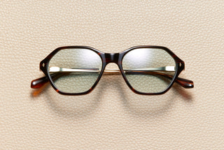 Audrey Fire sunglasses by L'Écurie Paris, hexagonal red-brown fire acetate frame with dusty blue lenses and 18K gold-plated titanium temples