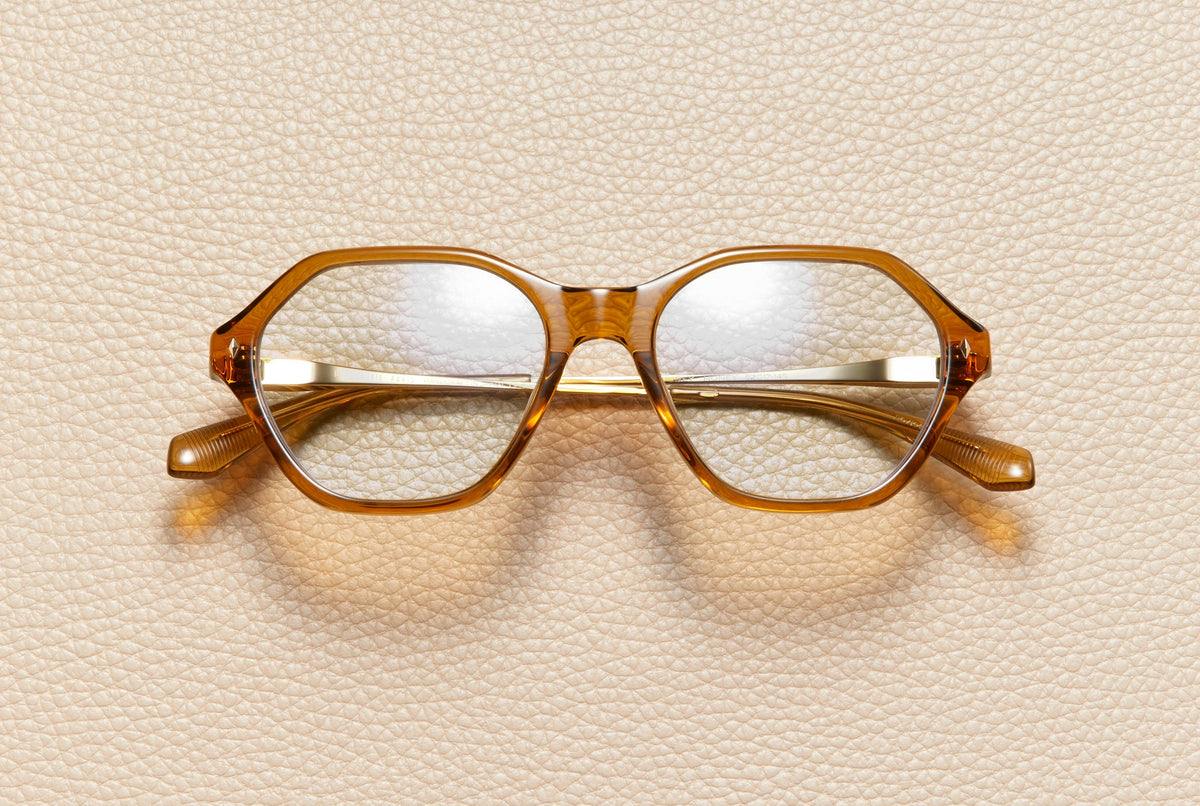 Audrey Honey optical frame by L'Écurie Paris, hexagonal translucent honey acetate with 18K gold-plated titanium temples, prescription ready