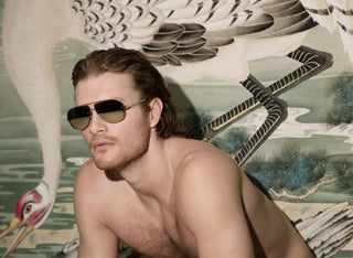 John VanBeber wearing L'Ecurie Paris sunglasses against a crane mural, Fashion For Men editorial