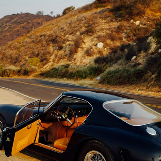 Vintage Ferrari berlinetta with open door on a canyon road